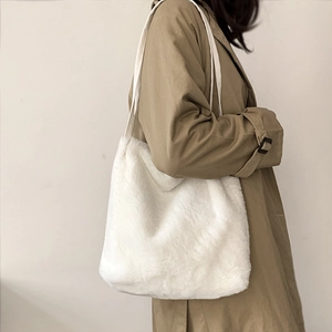 Détail d'un sac cabas en fausse fourrure blanche avec de fines bandoulières d'hiver