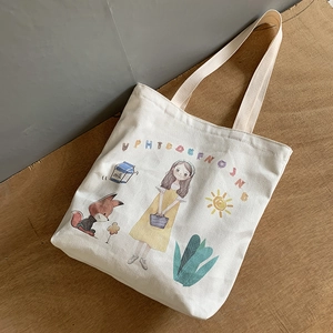 Detail of off-white canvas tote bag featuring cute cartoon girl and fox illustration