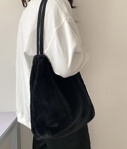 Détail d'un grand sac cabas noir en peluche avec texture en fausse fourrure douce