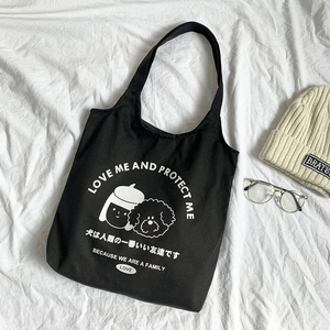 Détail du tote bag en toile noire avec illustrations d'animaux et texte stylisé