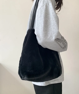 Vue détaillée du sac cabas en fausse fourrure noire avec fine bandoulière