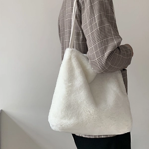 Gros plan du sac fourre-tout blanc en peluche montrant la fourrure et la bandoulière douce