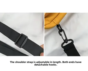 Detail of adjustable black woven strap with detachable hooks on yellow canvas bag
