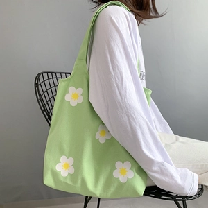 Green canvas tote bag with white daisy prints and wide straps for daily leisure