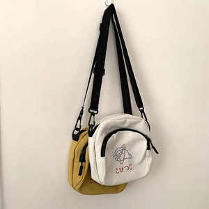 Détail du sac bandoulière en toile avec broderie mouton et sangle réglable en deux couleurs