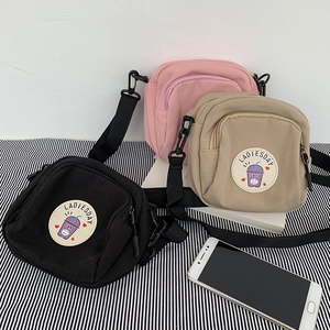 Detalle de minibolsos bandolera de nailon en negro, caqui y rosa con correa ajustable