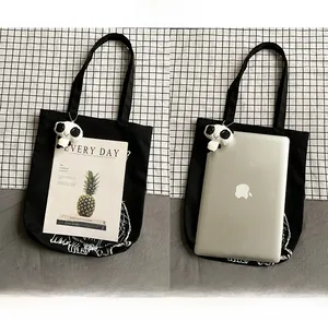 Black canvas tote showing storage capacity for 14-inch laptop and cute panda charm