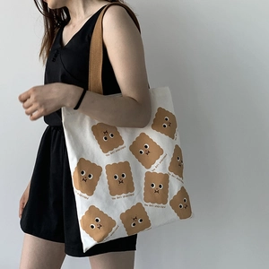 Détail du sac cabas en toile avec imprimé biscuit mignon et bandoulière tissée
