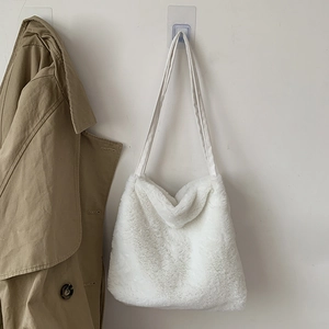 Détail du cabas en peluche blanche suspendu avec un trench-coat beige pour la taille