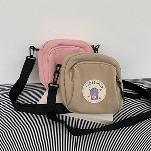 Detalle de bolsos bandolera de lona rosa y caqui con parche de Ladiesday