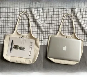 Detailansicht der cremefarbenen Canvas-Tasche mit Platz für 14-Zoll-Laptop und Magazin