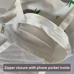 Détail du sac en toile blanc avec fermeture éclair et poche intérieure pour téléphone