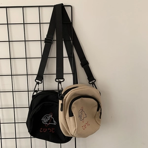 Détail d'imprimés moutons de dessin animé sur mini sacs bandoulière en toile avec sangles