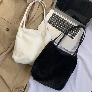 Détail de sacs cabas en fausse fourrure douce en noir et blanc avec fines lanières