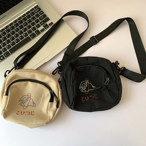 Détail du sac bandoulière en toile avec motif mouton et bandoulière réglable en nylon