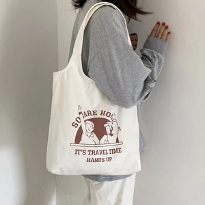 Canvas tote bag with vintage print shown on shoulder for daily casual outfit style