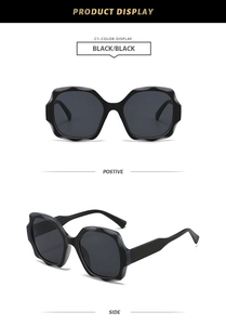 Detail view of oversized wavy square sunglasses in black showing front and side profiles