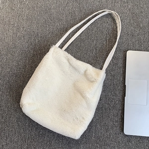 Détail d'un sac cabas en fausse fourrure blanche montrant la texture douce et pelucheuse