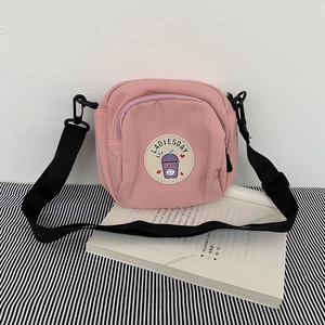Mini bolso bandolera de nylon rosa con parche de té con leche y correa ajustable