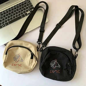 Vue détaillée du motif mouton et de la texture épaisse des sacs bandoulière en toile