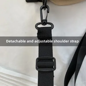 Détail d'une bandoulière noire réglable et amovible avec boucle rotative en métal