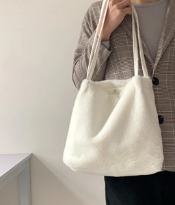 Gros plan sur le sac fourre-tout blanc en peluche avec texture douce et sangles