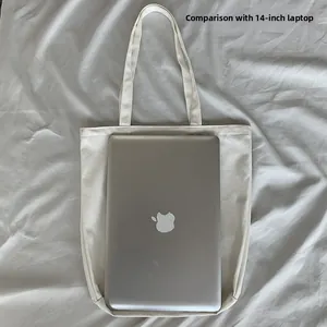 White canvas tote bag showing interior storage capacity for a 14-inch laptop