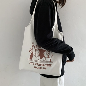 Side view of white canvas tote bag with travel illustration worn by a model