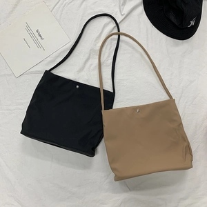 Minimalist nylon tote bags in black and khaki with silver snap closure and slim straps