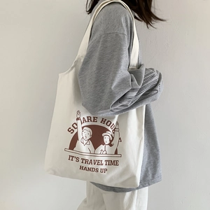 Detail of a minimalist canvas tote bag featuring brown line art and text on creamy white fabric