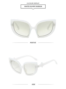 Detail view of white cat-eye sunglasses with star accents and silver mirrored lenses
