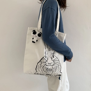 White canvas tote bag with artistic rabbit print and cute panda plush pendant