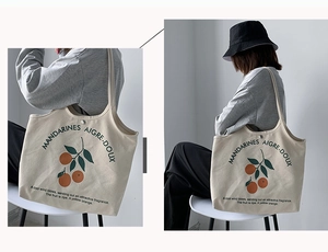 Détail du sac cabas en toile avec imprimé orange jaune et bouton pression en métal