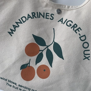 Gros plan détaillé sur l'imprimé fruit du sac en toile avec un bouton pression argent