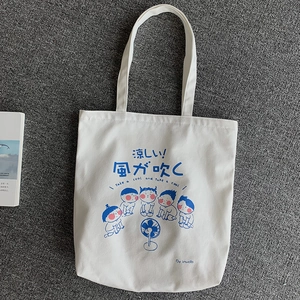 Detail of white canvas tote bag featuring Japanese cartoon kids cooling by a fan