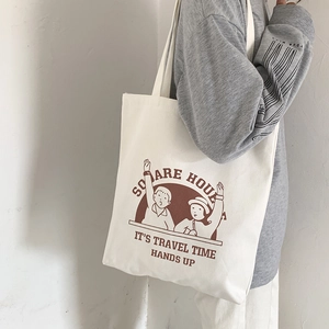 Detailed close-up of a white canvas tote bag with vintage brown illustration and text