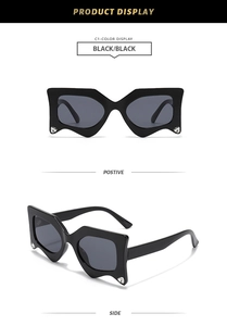 Detail view of black geometric sunglasses with rhinestone accents on the lower frame edges