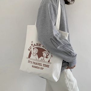 Detail of white canvas tote bag featuring vintage cartoon print and travel time text