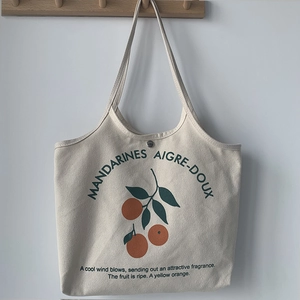 Vue détaillée du sac cabas en toile avec imprimé orange et fermeture magnétique en métal