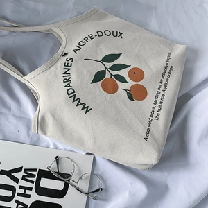 Détail du sac cabas en toile crème avec imprimé orange et typographie française élégante