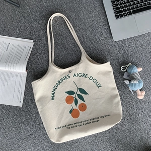 Détail du cabas en toile montrant l'illustration d'oranges et texte français sur crème