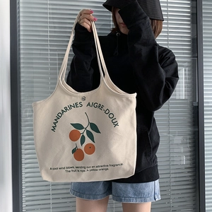 Détail du sac cabas en toile montrant le fermoir magnétique et l'imprimé orange fruité