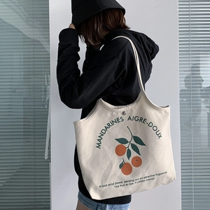 Détail du sac cabas en toile avec imprimé orange et boucle métallique robuste