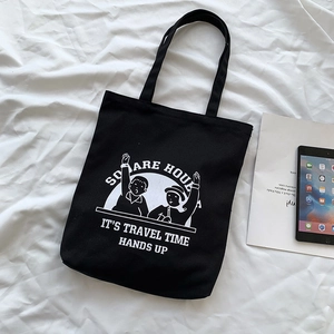 Detail of black canvas tote bag featuring vintage graphic print and sturdy handle design
