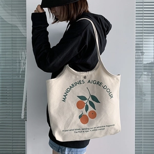 Détail du sac cabas en toile avec imprimé orange et fermeture à bouton-pression