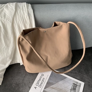 Detail of magnetic snap closure and minimalist khaki nylon tote bag interior
