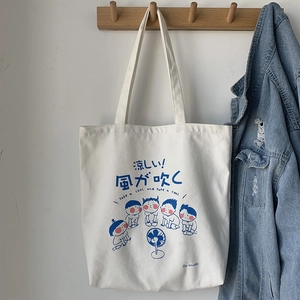 Japanese style white canvas tote bag featuring cute blue cartoon characters on a wall hook