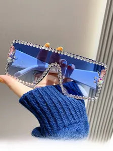 Macro detail of rectangle sunglasses with blue gradient lenses and rhinestone-encrusted frame