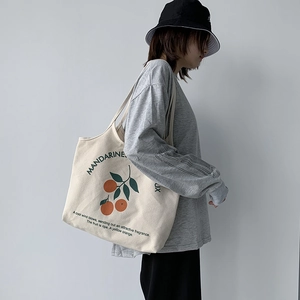 Détail du sac cabas en toile avec imprimé mandarine et typographie sur le côté