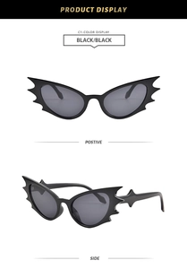 Detail view of bat-shaped sunglasses with black frames and dark grey lenses for parties